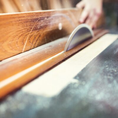Carpenter sawing wooden planks